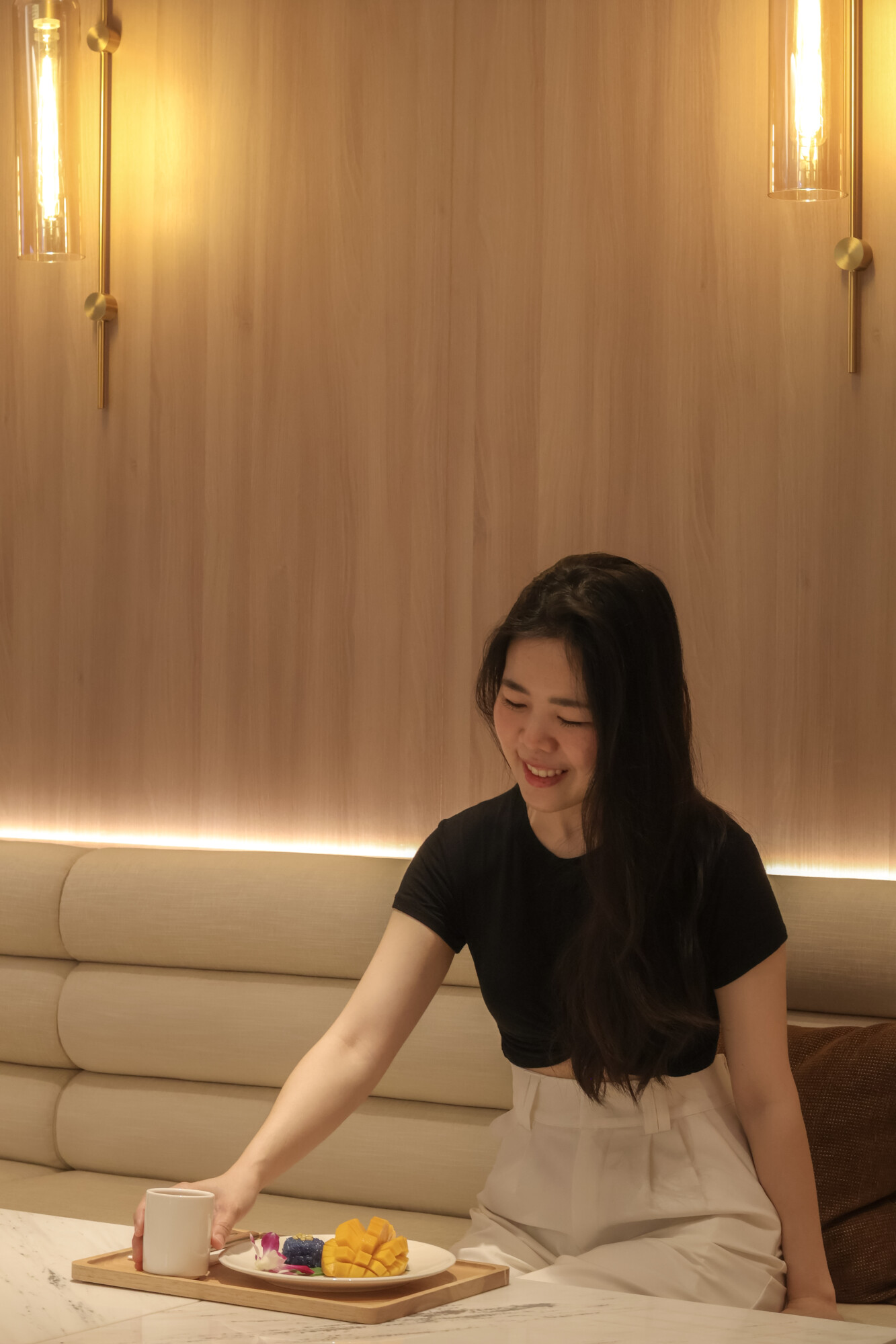 A woman drinking water and eating fruit after a massage