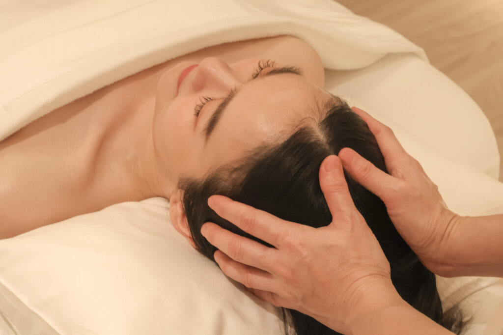 A woman experiencing a traditional Indian head massage
