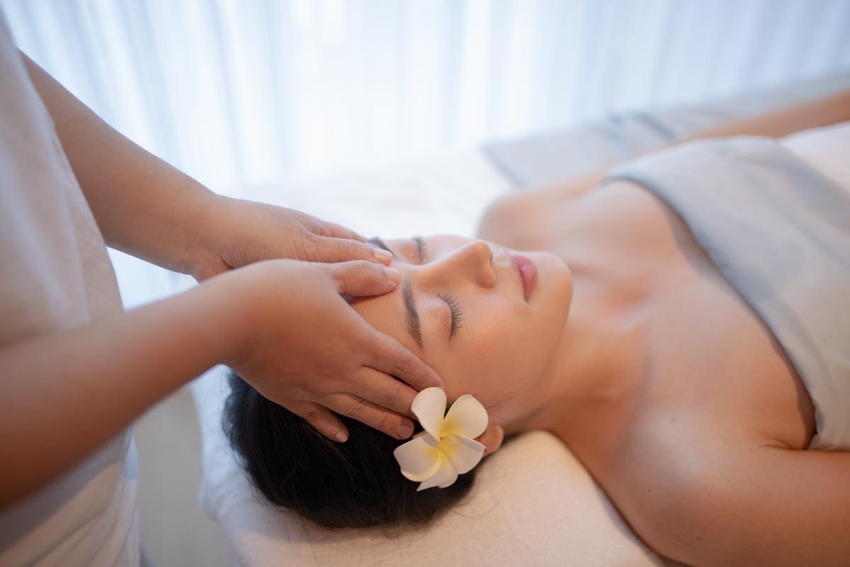 A therapist providing an Indian head massage in Bangkok