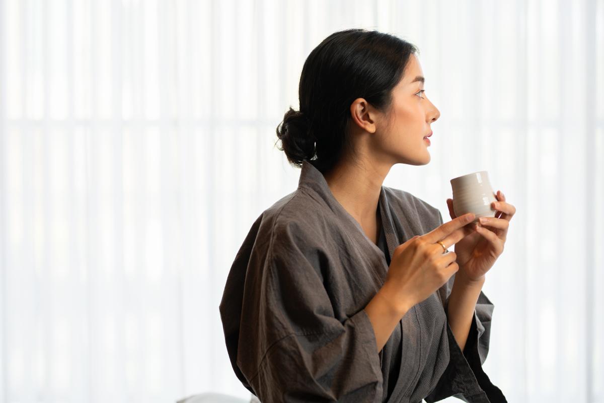 A woman enjoying her complimentary tea after a facial treatment