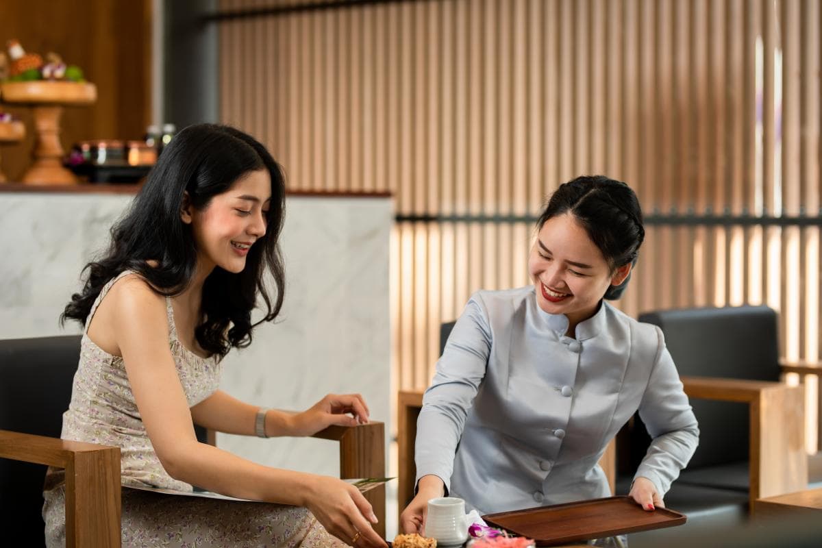 A Makkha Health & Spa therapist offering hot tea to a guest
