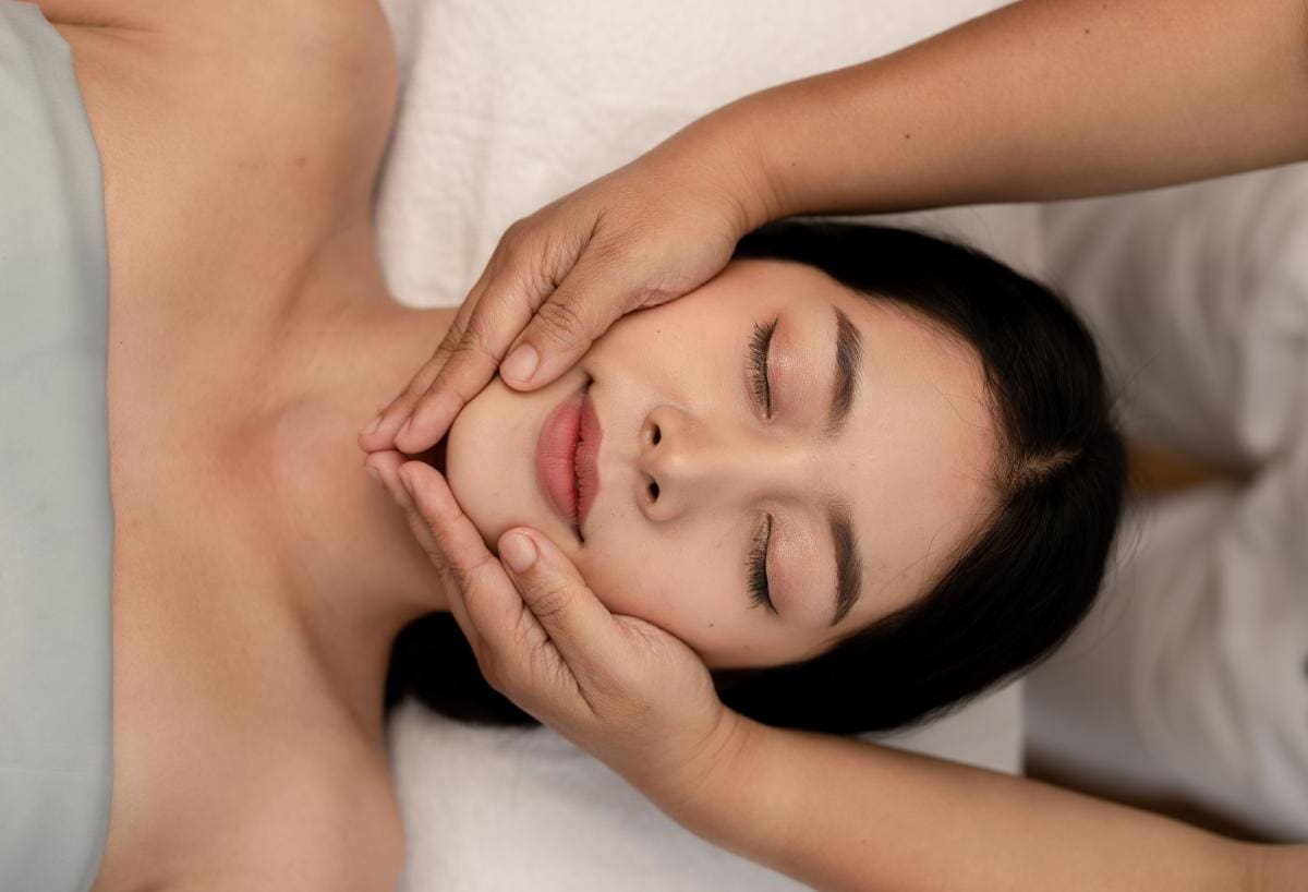 A relaxed woman receiving a Thai facial treatment in Bangkok