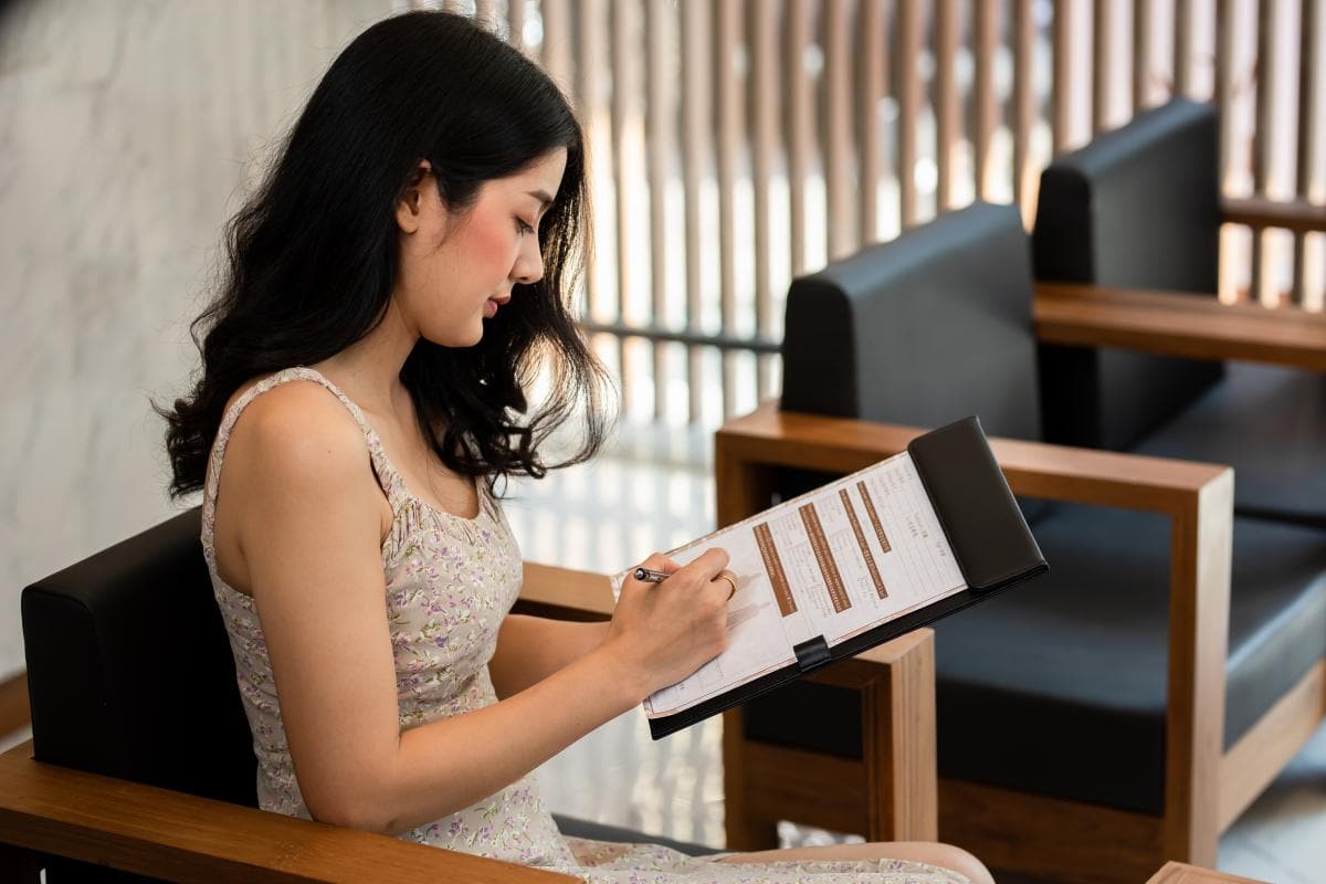 A woman completing a questionnaire before her massage