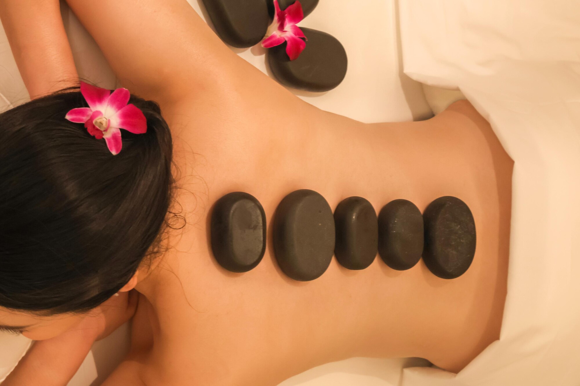 Relaxing hot stone massage on woman's back
