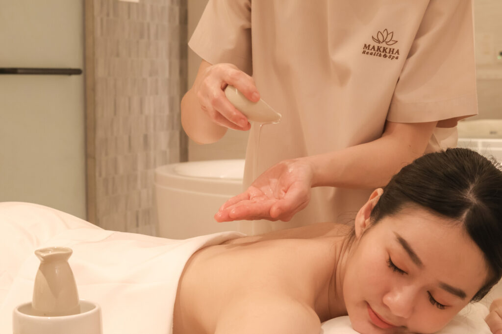 A therapist about to perform an oil massage on a client