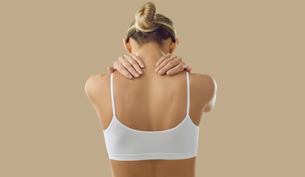 A woman suffering from a pinched nerve at the back of the neck